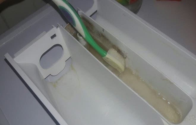 Помити лоток для порошку зубною щіткою
